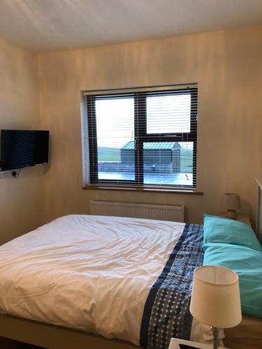 - une chambre avec un lit et une fenêtre dans l'établissement Killard House, à Caherlean
