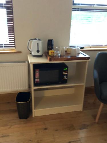 a microwave on a stand in a room with a window at Killard House in Caherlean