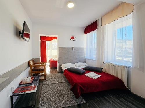 1 dormitorio con 1 cama con manta roja en Hotel Simeria, en Gura Humorului