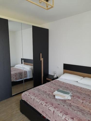 1 dormitorio con 1 cama grande y espejo en Casa Vacanza "Aurora", en Costa Volpino