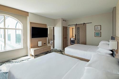 een hotelkamer met 2 bedden en een flatscreen-tv bij Sheraton Suites Columbus Worthington in Columbus