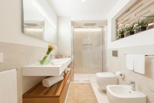 une salle de bain blanche avec un lavabo et des toilettes dans l'établissement ByMe Torino 85, à Turin