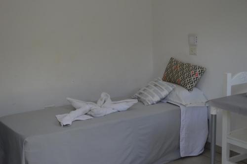 Una cama blanca con un montón de toallas. en Apart Hotel Verona en Puerto Madryn