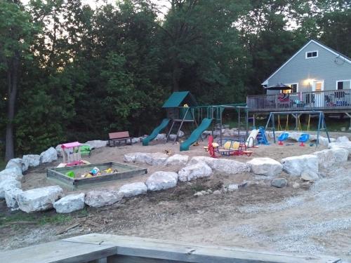 un parque infantil con un tobogán y un juego de juegos en Bayshore Cottages, en Wiarton