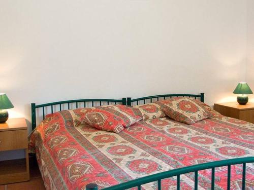 1 cama en un dormitorio con 2 lámparas en las mesas en Scopello sul mare 2, en Castellammare del Golfo