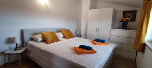 1 dormitorio con 1 cama blanca grande con almohadas de color naranja en Apartment Lorena, en Kaštelir