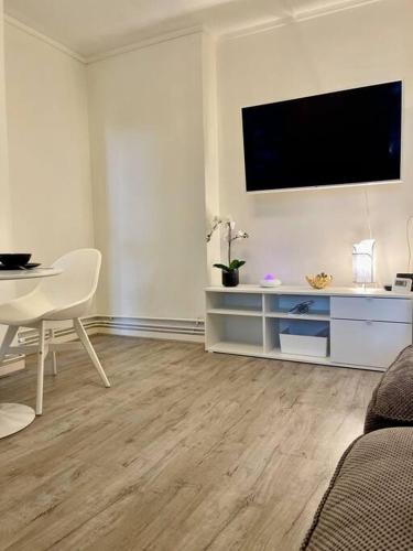 a living room with a table and a television on the wall at 1 bed apartment in Zone 2, minutes from Oval tube. in London