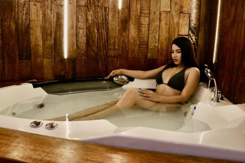 una mujer sentada en una bañera en Avanti Zorritos, en Bocapán