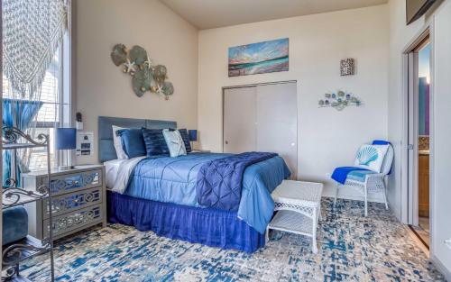 1 dormitorio con 1 cama azul y 2 sillas en Pirates Cove View, en Depoe Bay