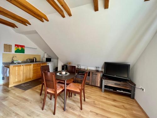 a kitchen and dining room with a table and a tv at Apartmán Linda Tále in Tale