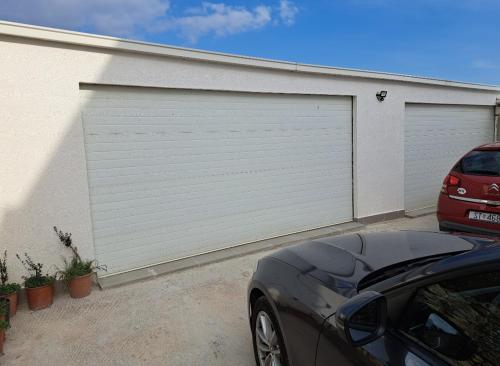 a garage with a car parked in front of it at Beautiful duplex apartment with view in Kaštela