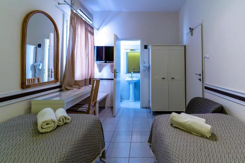 a hotel room with two beds and a bathroom at Manto Hotel in Mýkonos City