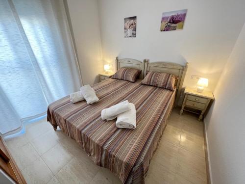 a bedroom with a bed with two towels on it at Casa JORGE in Torrevieja