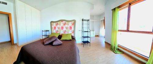 a bedroom with a large bed with green pillows at Casa de la Luz in Carboneras