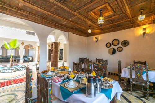een eetkamer met tafels en stoelen en een plafond bij Riad Jouba in Merzouga