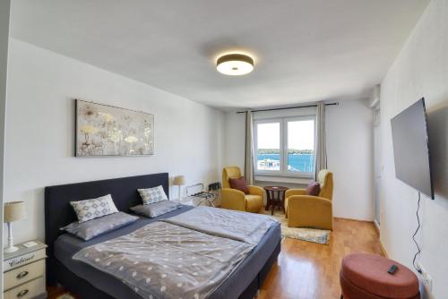 a bedroom with a bed and chairs in it at Studio Apartment Harbour Pula in Pula