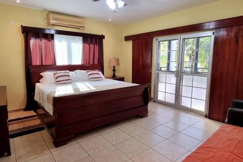 een slaapkamer met een groot bed en een glazen schuifdeur bij Huellas en la arena Casa De Playa in Tela