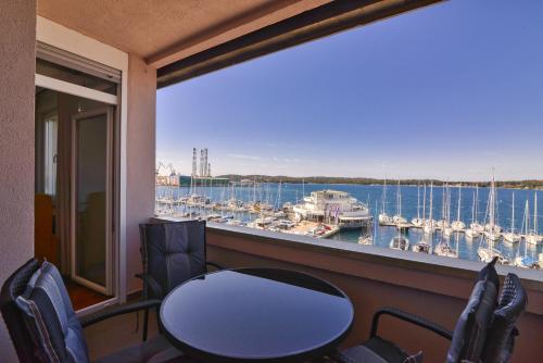a balcony with a table and chairs and a view of a marina at Studio Apartment Harbour Pula in Pula