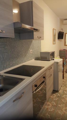 a kitchen with a sink and a counter top at piccolo monolocale al porticciolo in Isola Rossa