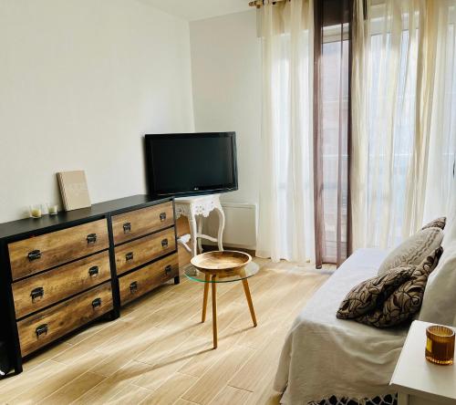 a bedroom with a dresser with a flat screen tv at Cosy Studio in Sète