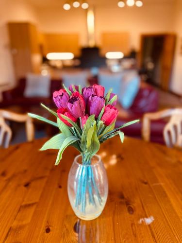 a vase filled with pink flowers sitting on a table at Talisker in Nairn