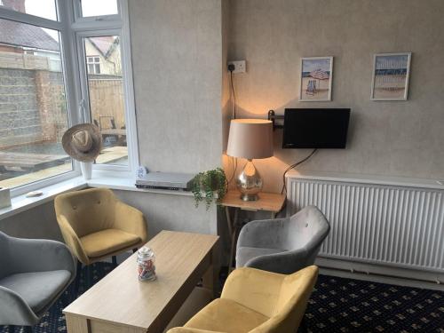 a waiting room with chairs and a table and a tv at Knighton Lodge in Skegness