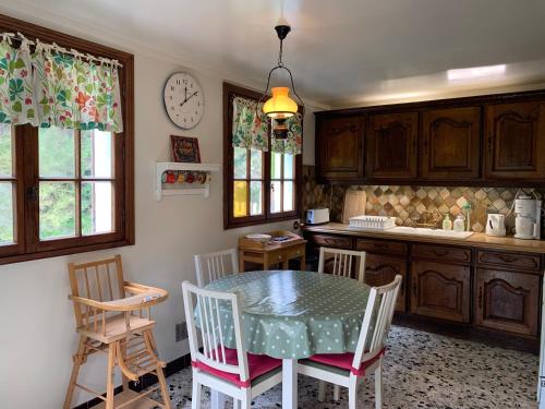 une cuisine avec une table, des chaises et une horloge dans l'établissement La Flore Marine, à Saint-Jouin-Bruneval