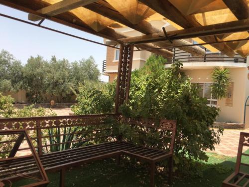 a wooden bench sitting under a pergola at الجبل الاخضر سيق ( بيت الصوير ) in Sayq