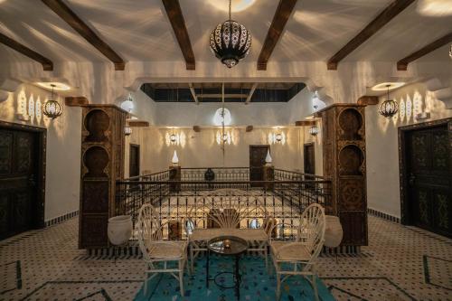 a dining room with a table and chairs and a chandelier at Riad Jouba in Merzouga