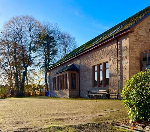 a brick building with a bench in front of it at Macallen in Nairn