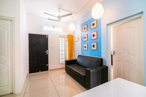 czarne krzesło w pokoju z niebieską ścianą w obiekcie Super OYO Thykoodam Apartments w mieście Koczin