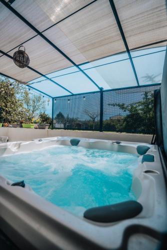 - une baignoire jacuzzi avec eau bleue dans la chambre dans l'établissement Le Titibu, Gîte 5 étoiles avec Spa entre Ardèche et Cèze, à Saint-Paulet-de-Caisson