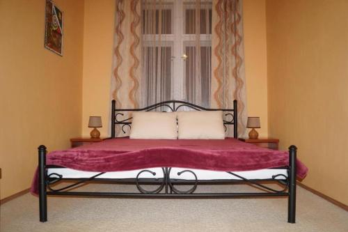 un letto con una coperta rossa e una finestra di Dream appartment for a nice holiday with a bedroom and living room! a Mariánské Lázně