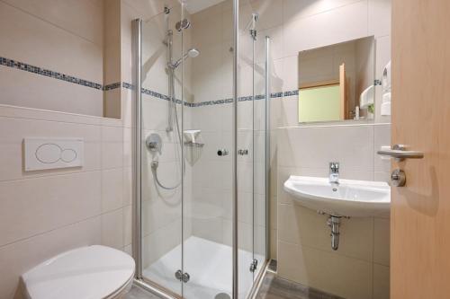 a bathroom with a shower and a toilet and a sink at Rote Villa Füssen in Füssen