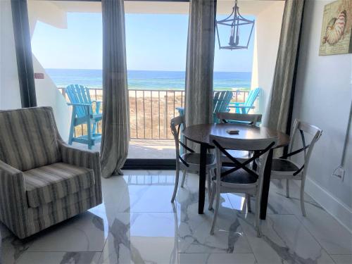 a dining room with a table and chairs and the ocean at Island Winds East 202 by ALBVR - Beautifully renovated beachfront condo & steps away from Hangout & more! in Gulf Shores