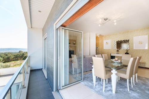 a dining room and living room with a table and chairs at Alohouse Nazaré in Nazaré