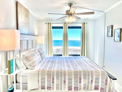 a bedroom with a bed with a view of the ocean at Island Winds East 202 by ALBVR - Beautifully renovated beachfront condo & steps away from Hangout & more! in Gulf Shores