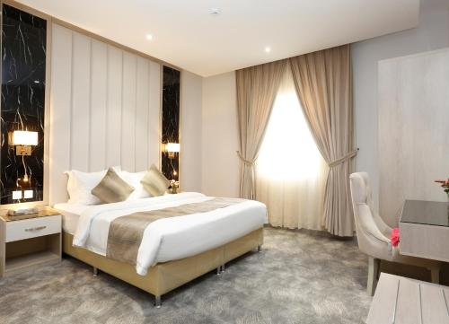 um quarto de hotel com uma cama grande e uma janela em وايت مون للأجنحة الفندقية -الرصراص em Khamis Mushayt