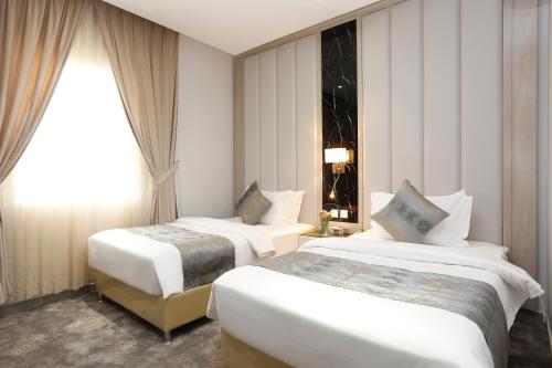 Łóżko lub łóżka w pokoju w obiekcie وايت مون للأجنحة الفندقية -الرصراص