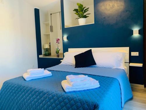- une chambre avec un lit bleu et des serviettes dans l'établissement TibetiAmo, à Castelsaraceno