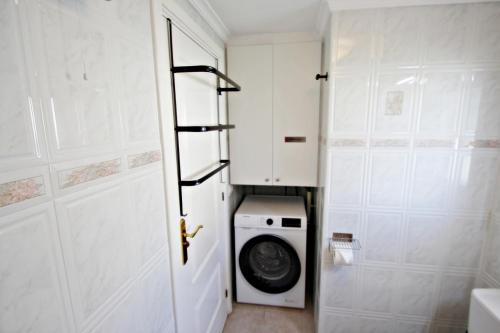 a laundry room with a washing machine and a door at El Bruni - modern villa close to the beach in Benissa in Pedramala