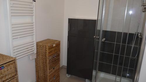 - une cuisine avec un réfrigérateur noir dans la chambre dans l'établissement Les Grenadines du samedi au samedi, à Antibes