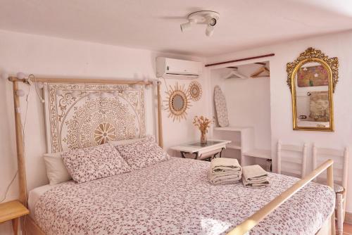 1 dormitorio con 1 cama grande y espejo en Finca Sábila, en Valle de Abdalajís