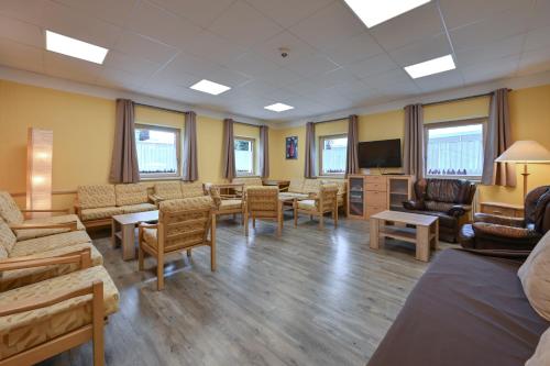 a waiting room with furniture and a flat screen tv at Rote Villa Füssen in Füssen
