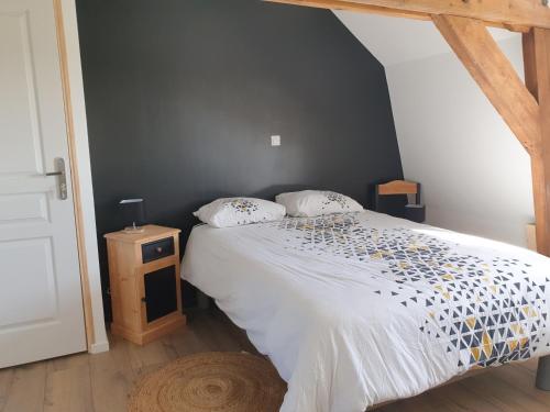 a bedroom with a bed with a white comforter at Le Moole Veld in Steenbecque