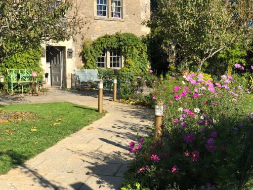 a garden with flowers in front of a house at Pear Tree Inn Whitley in Whitley