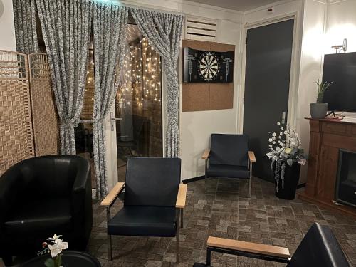 a waiting room with two chairs and a fireplace at Hotel Dijkzicht in Oudeschip