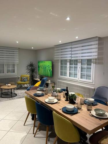 - un salon avec une grande table en bois et des chaises dans l'établissement Maison familiale face à la mer, à Regnéville-sur-Mer