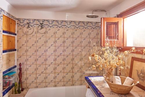 uma casa de banho com uma banheira e uma parede de azulejos em Finca Sábila em Valle de Abdalagís