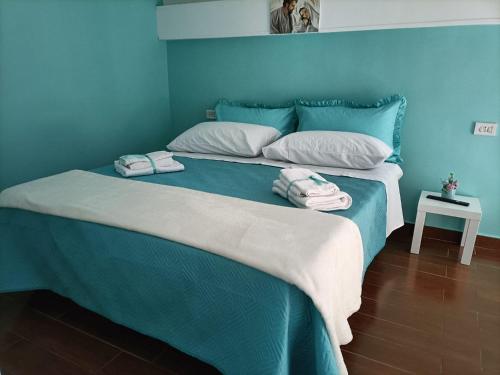 una camera blu con un letto e asciugamani di Napoli nel cuore a Napoli